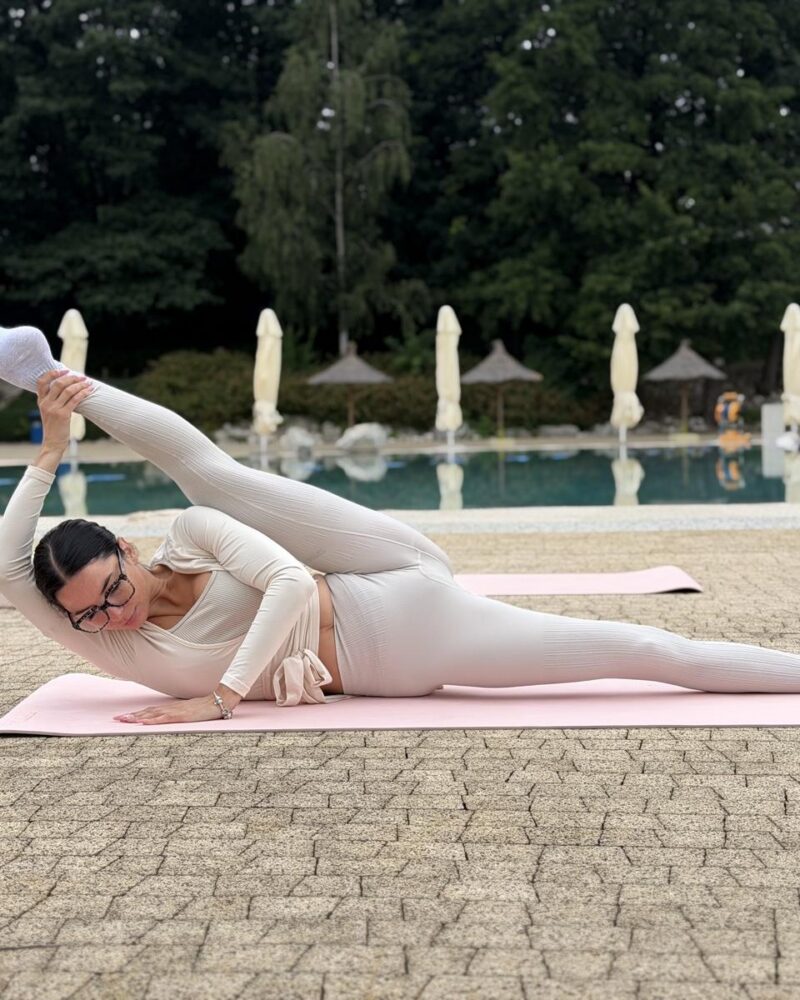 Pilates na macie przy basenie
